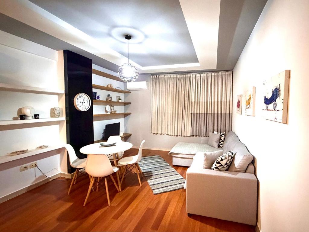 una sala de estar con un sofá y una mesa en Ergi’s Host Apartment, en Tirana