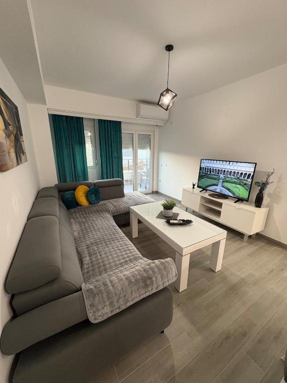 a living room with a couch and a tv at Siena Lux Apartment in Gevgelija