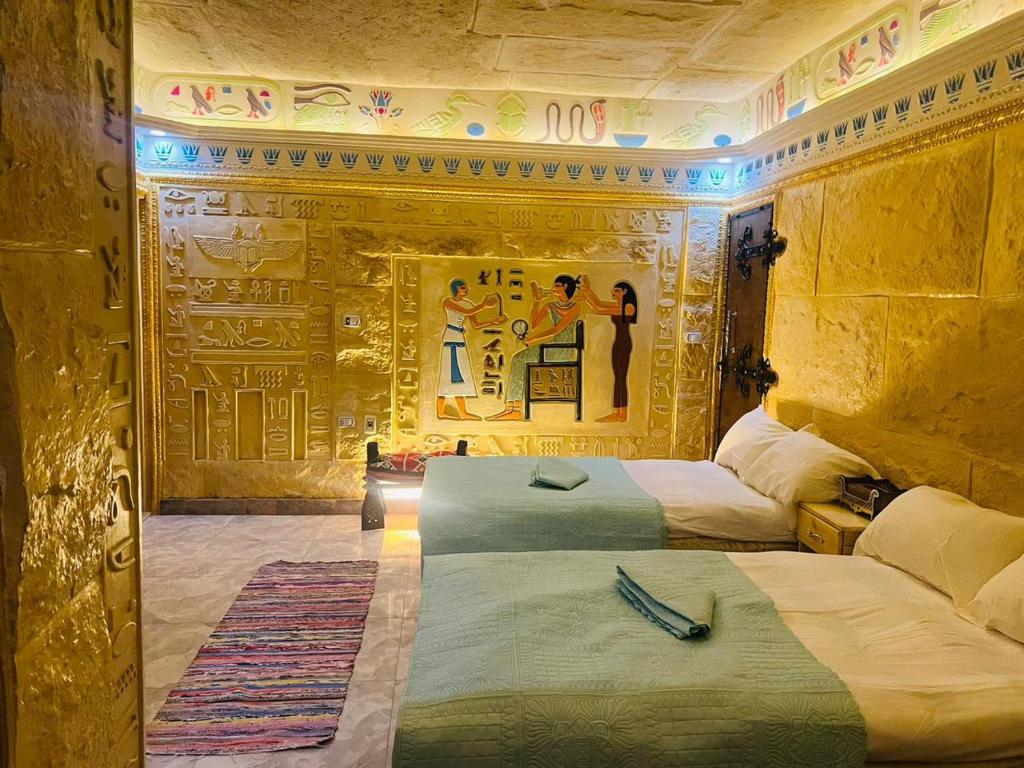 una stanza con due letti e un dipinto sul muro di Pyramids Mystery Inn a Il Cairo