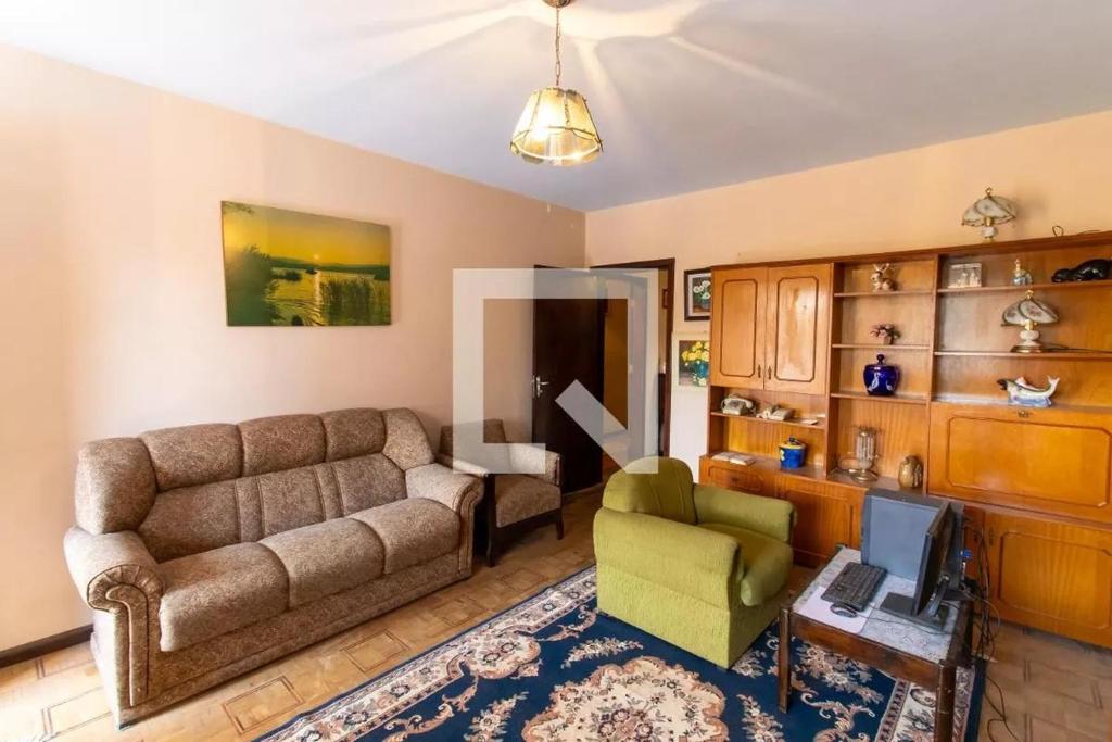 a living room with a couch and a chair at Apartamento 04 old no Capão da Imbuia in Curitiba