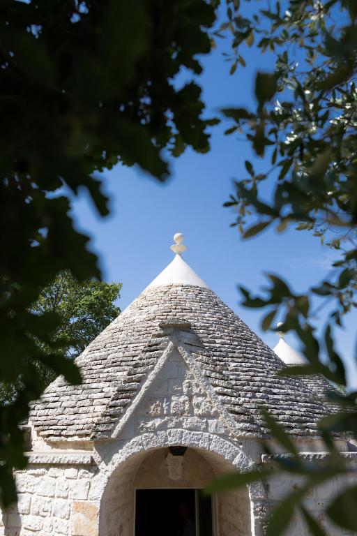 a steeple of a building with a cross on it at I Trullarelli in Cozzana