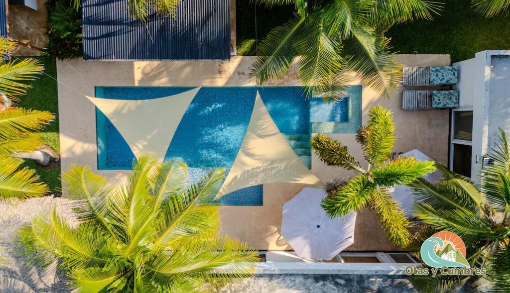 TaxiscoVilla Los Delfines 1的棕榈树环绕的建筑的鸟瞰图