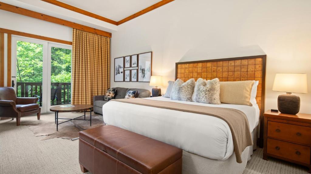 une chambre avec un grand lit et un balcon dans l'établissement 1117 Lodge At Spruce Peak Ski In Ski In Ski Out King Studio By Stowe Mountain Rentals, à Stowe