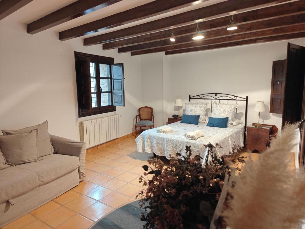 ein Wohnzimmer mit einem Bett und einer Couch in der Unterkunft Casona Arquillo del Judío in Toledo