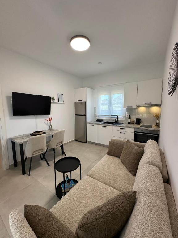 ein Wohnzimmer mit Couch und Tisch und eine Küche in der Unterkunft Taras Studio in Karavádhos