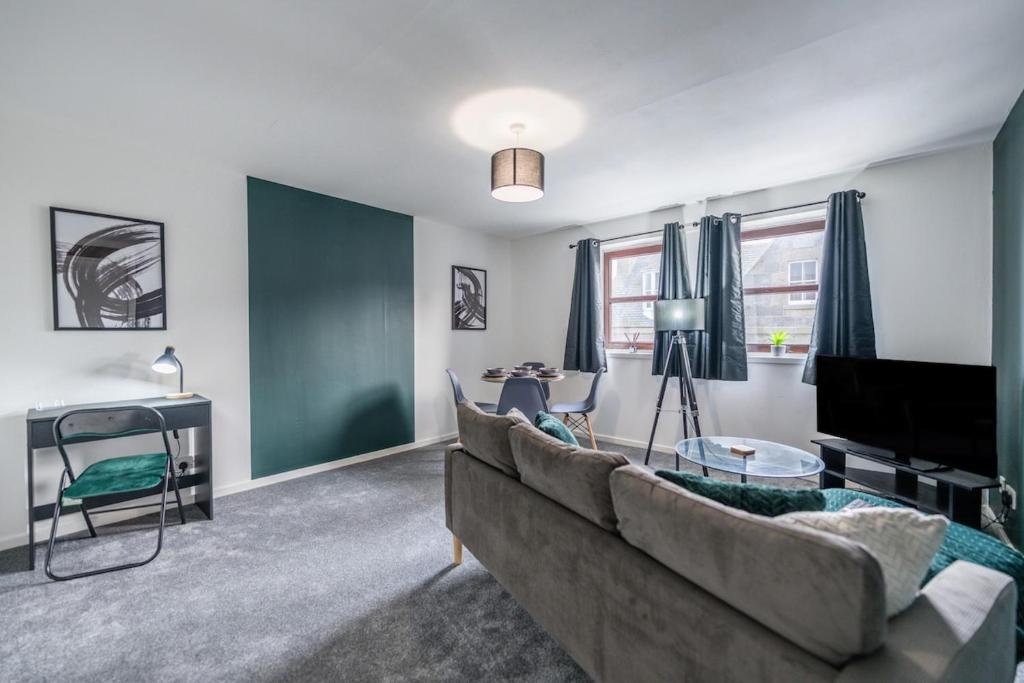 a living room with a couch and a television at Fraserburgh Apartment - 2 bed, free parking & wifi in Fraserburgh