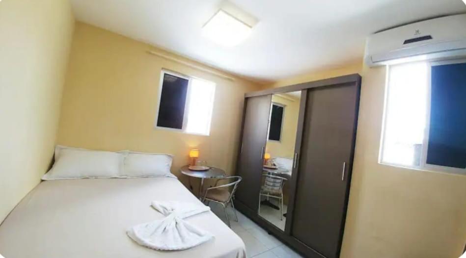 a bedroom with a bed with a towel on it at Suíte INDIVIDUAL com Ar condicionado em AP Compartilhado in João Pessoa