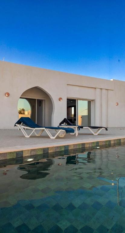 a house with a pool of water in front of it at Djerba Dar Iyad in Mezraya