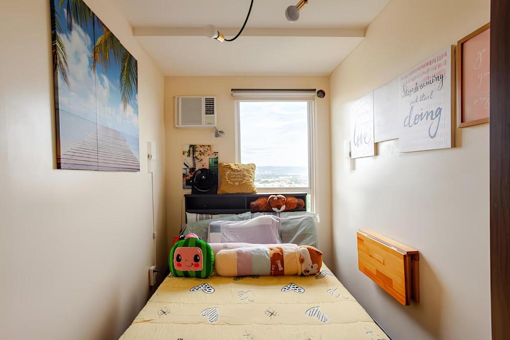 a small room with a bed and a window at Cheapest Staycation at the Metro in Manila