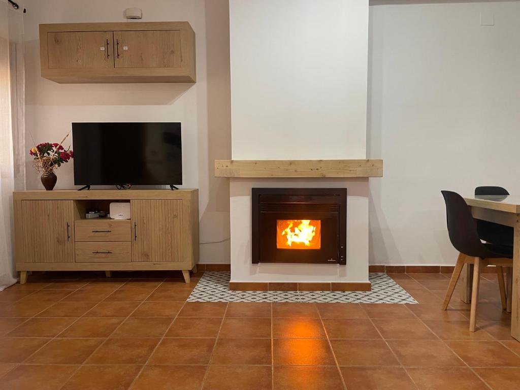 ein Wohnzimmer mit Kamin und Fernseher in der Unterkunft El Oasis of Ruidera in Ruidera
