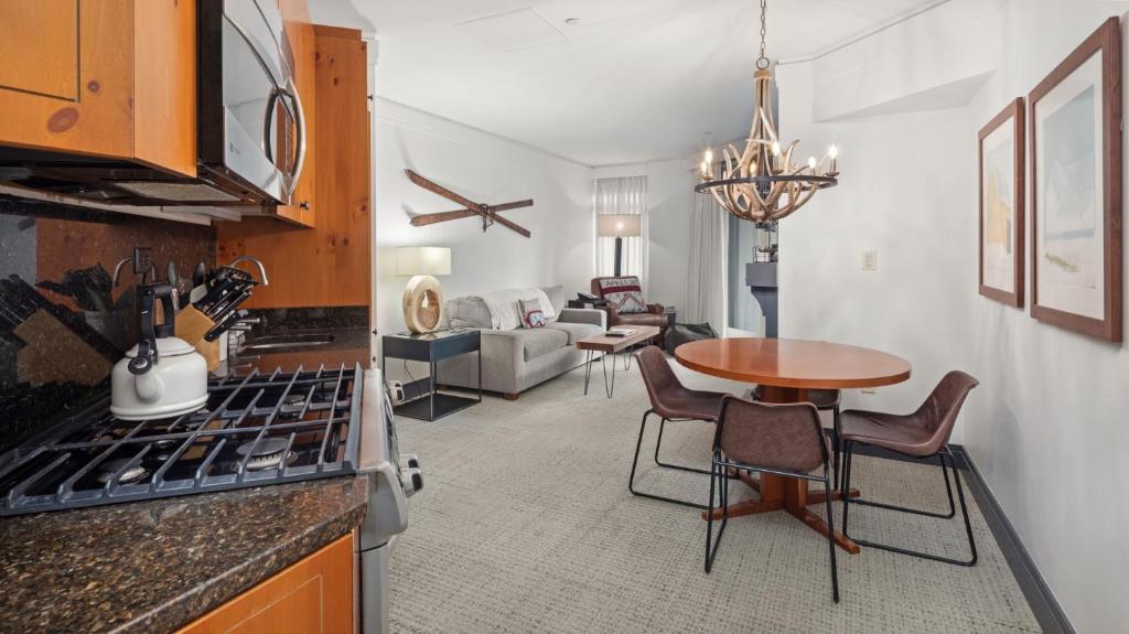 une cuisine avec une table et un salon dans l'établissement 1302 Lodge At Spruce Peak Ski In Ski Out Two Bedroom By Stowe Mountain Rentals, à Stowe