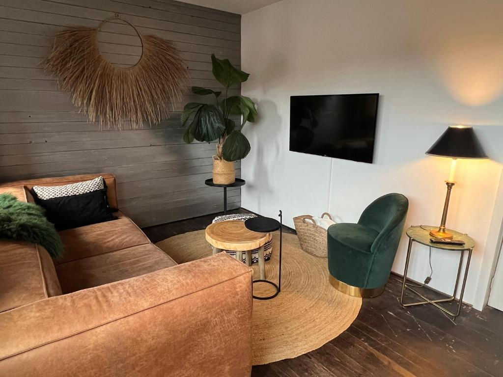 Una sala de estar con un sofá y un televisor en Van de Gruiterwonen, en Axel