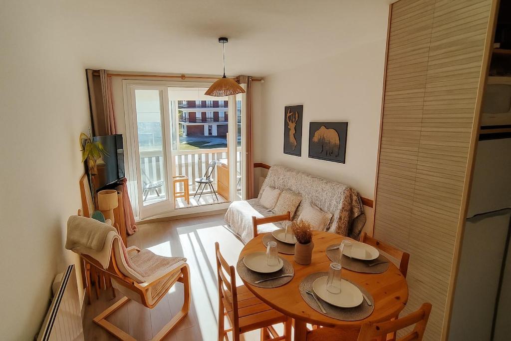 ein Wohnzimmer mit Tisch und Couch in der Unterkunft Family Lodge Grand Tetras Les Angles in Les Angles