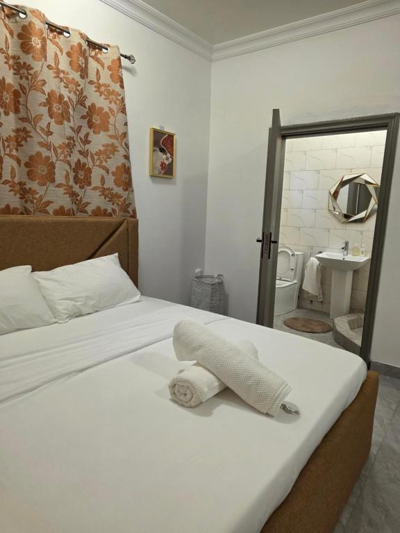 une chambre d'hôtel avec un lit avec une serviette dessus dans l'établissement Private en - suite room near airport, à Madina