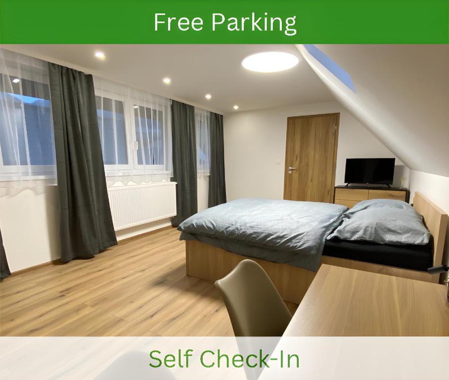 ein Schlafzimmer mit einem Bett und einem Schreibtisch mit einem Fernseher in der Unterkunft Apartmánový dom Višňové in Višňové