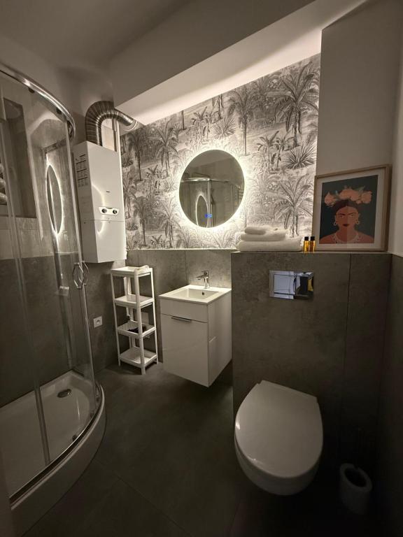 een badkamer met een toilet, een wastafel en een spiegel bij Apartament Staffa in Zielona Góra