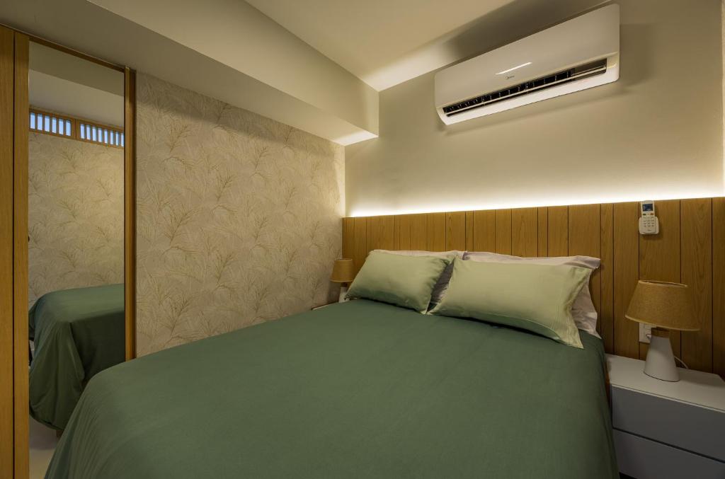 a bedroom with a green bed and a mirror at Luxo na Gloria in Rio de Janeiro