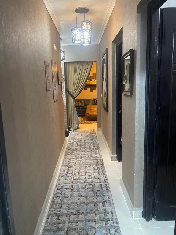 a hallway with a tile floor and a hallway with a chandelier at Cozy Comfort Flat , Madinaty in Cairo