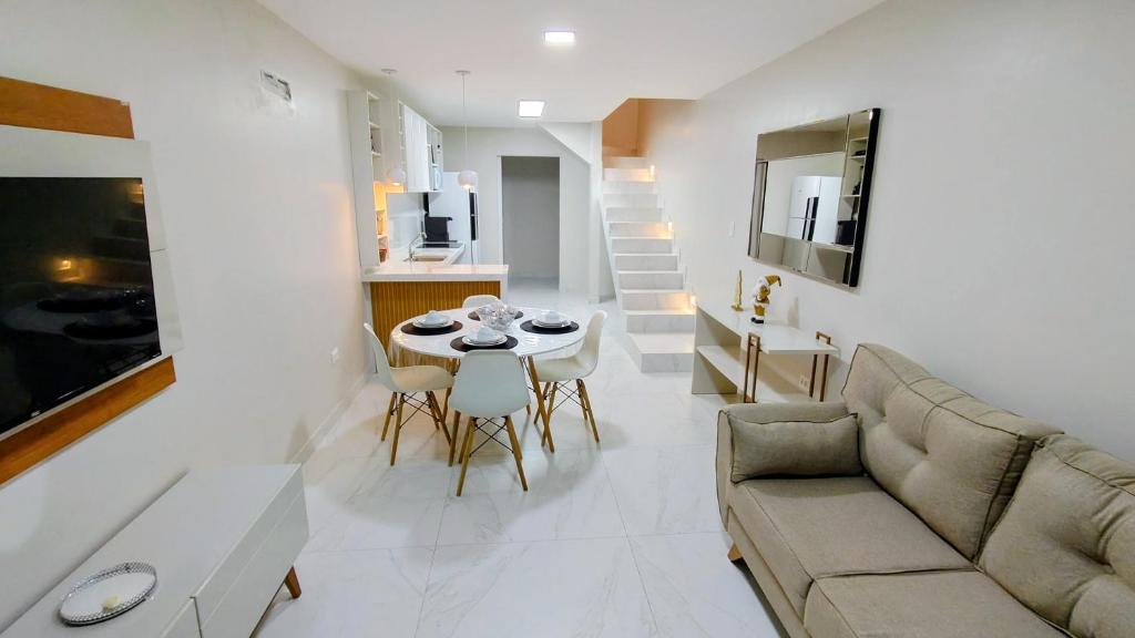 a living room with a couch and a table and chairs at Linda casa em Garanhuns-PE in Garanhuns