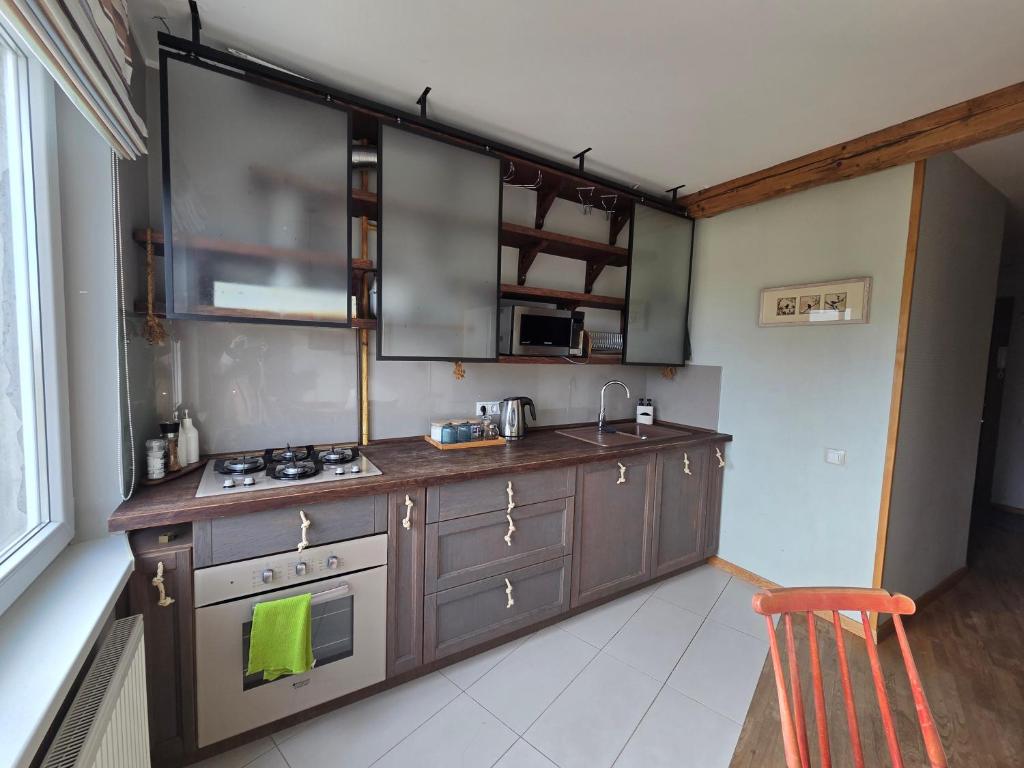 a kitchen with a stove and a sink in it at Apartamentai 78 in Mažeikiai