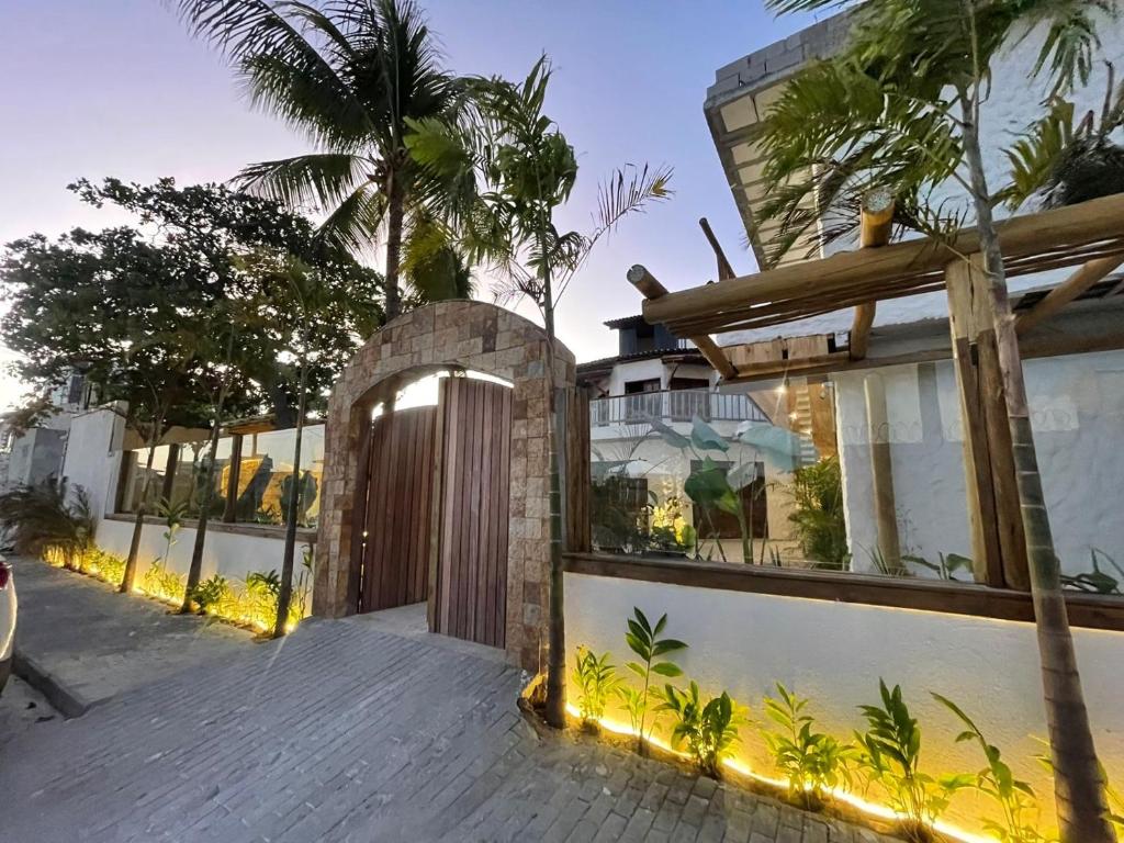 ein Haus mit einem Holztor und einer Palme in der Unterkunft Villa da Praia -Orla de Atalaia in Aracaju