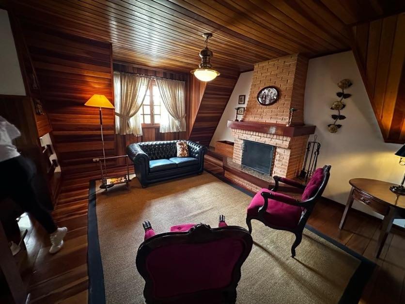 una sala de estar con un sofá y una chimenea en Chalé Luxuoso Capivari em Campos do Jordão, en Campos do Jordão