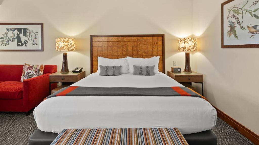 ein Hotelzimmer mit einem großen Bett und einem roten Sofa in der Unterkunft #337 Inside Lodge At Spruce Peak Studio Ski in in Ski out By Stowe Mountain Rentals in Stowe