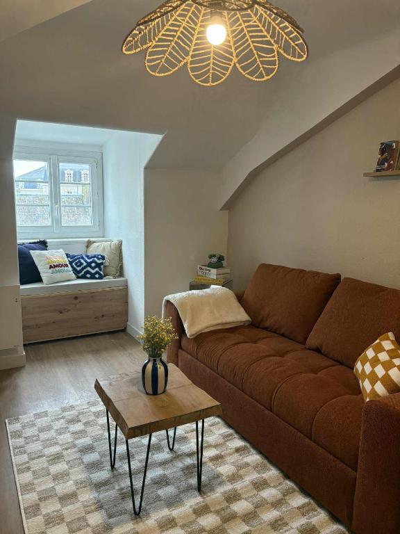 un salon avec un canapé marron et une table dans l'établissement Charmant appartement - Le Dopamine, à La Roche-sur-Yon