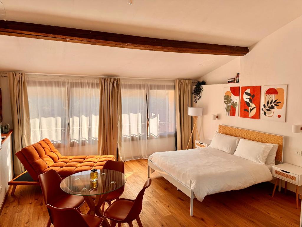 多尔切阿夸Il Nido - Guest house的一间卧室，里面有一张床、一张沙发和一张桌子