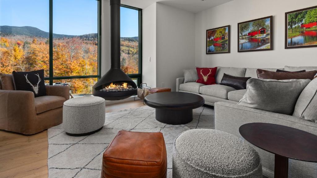 un salon avec un canapé et une cheminée dans l'établissement Lux Mountainside 2 Bed Mountainside Condo By Stowe Mountain Rentals, à Stowe