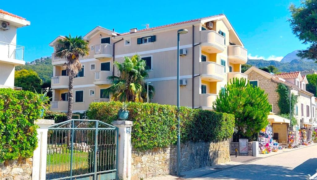 伊加洛Igalo Montenegro - Nice apartment 20 m from the sea!的街道前有围栏的建筑物