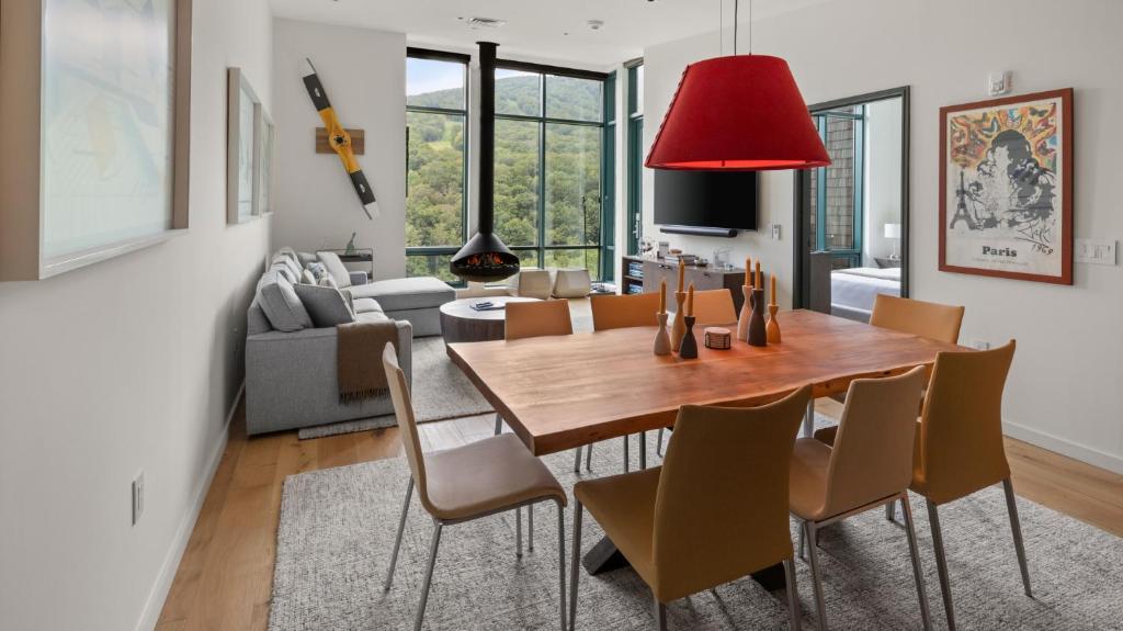 une salle à manger et un salon avec une table et des chaises dans l'établissement New Spruce Peak Tree House Unit Steps To The Lifts With Big Mountain Views Sleeps 9 By Stowe Mountain Rentals, à Stowe