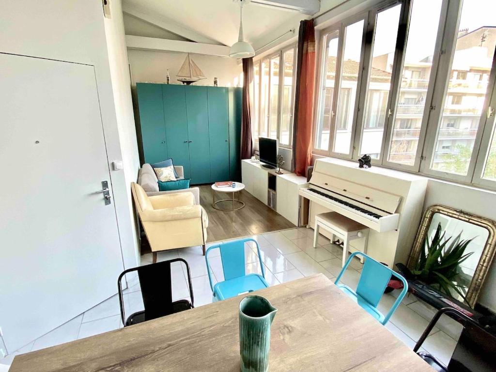 a living room with a table and a piano at The Artist in Clichy