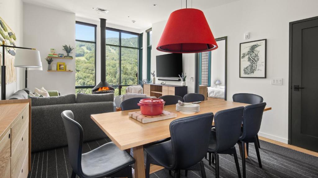 une salle à manger et un salon avec une table et des chaises dans l'établissement Stowe Mt Resort Treehouse Ski in Ski Out Mt Views By Stowe Mountain Rentals, à Stowe