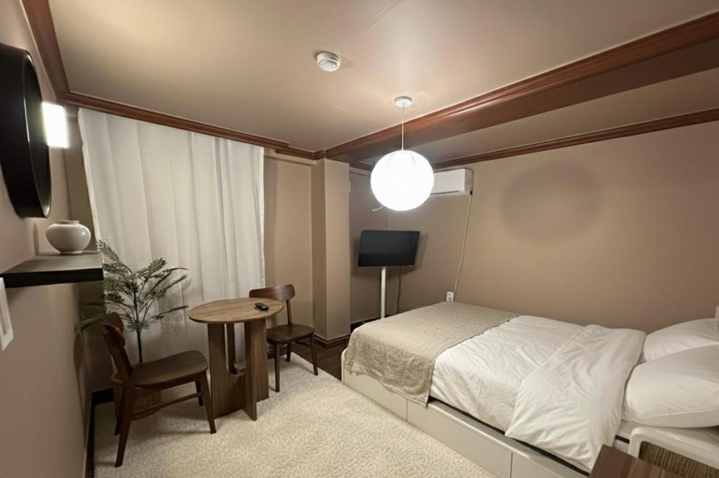 Un dormitorio con una cama, una mesa y un televisor. en 부일파크, en Suwon