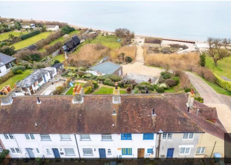 an aerial view of a house with the ocean in the background at Cowes View Seaside beach cottage, in Hill Head