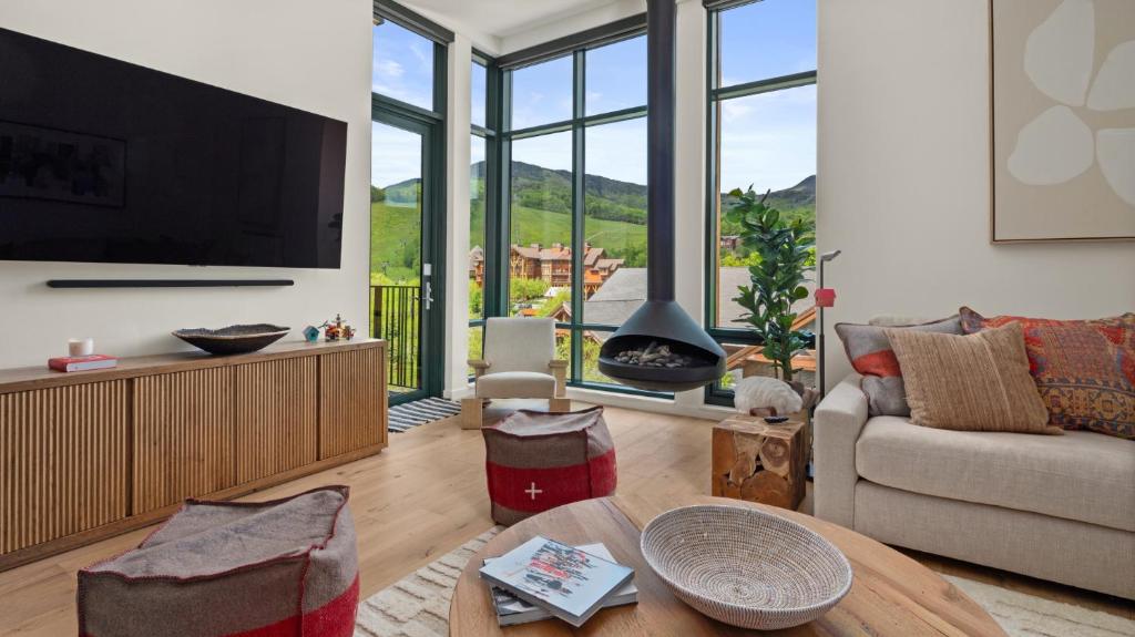 un salon avec une télévision et un canapé dans l'établissement Stowe Mt Resort Spruce Peak 4 Bed Treehouse Condo By Stowe Mountain Rentals, à Stowe