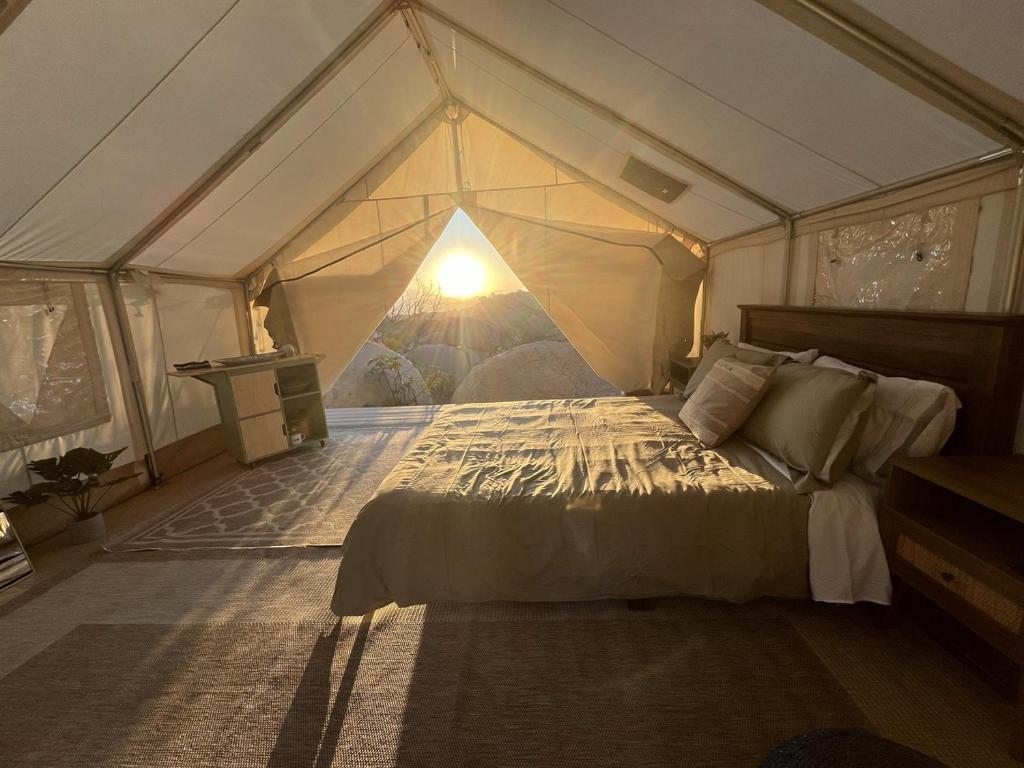 ein Schlafzimmer mit einem Bett in einem Zelt in der Unterkunft Cozy Mountain View Glamping Tent in De Luz Heights