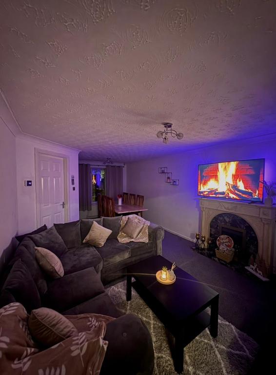 a living room with a couch and a fireplace at Tartan Nest- Entire house- Sleeps 8 guests in Mansewood