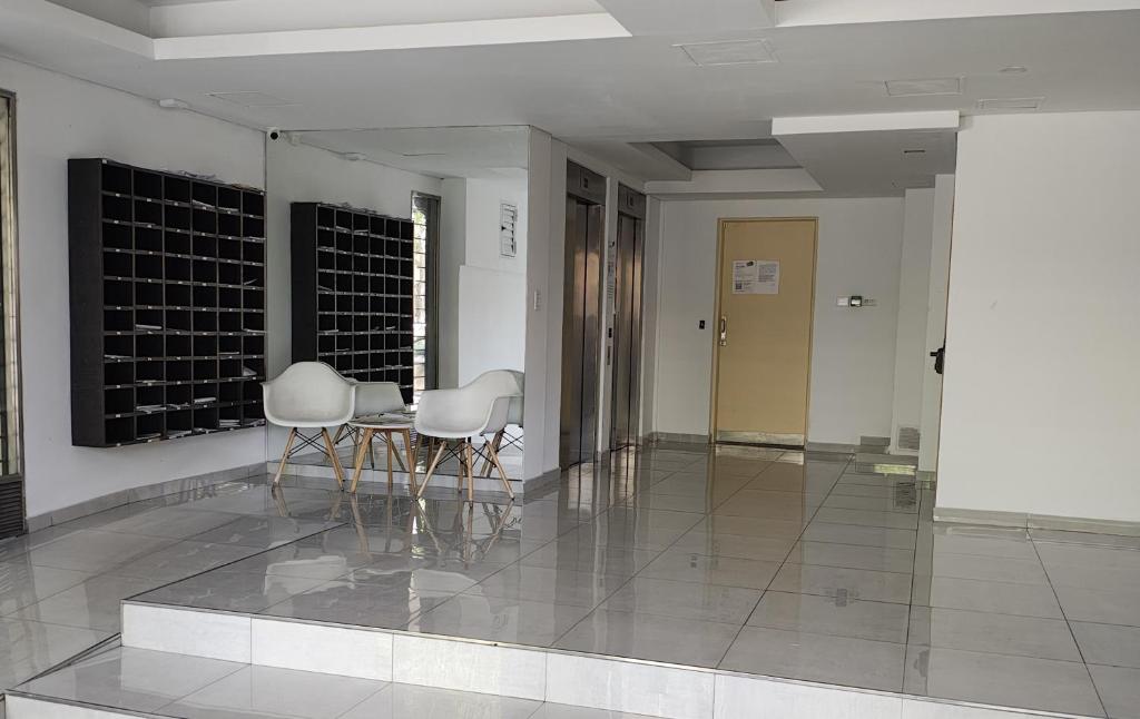 a hallway with chairs and a table in a building at LoftPoint Rosario, Pileta, Solarium y Terraza con vista al Río in Rosario