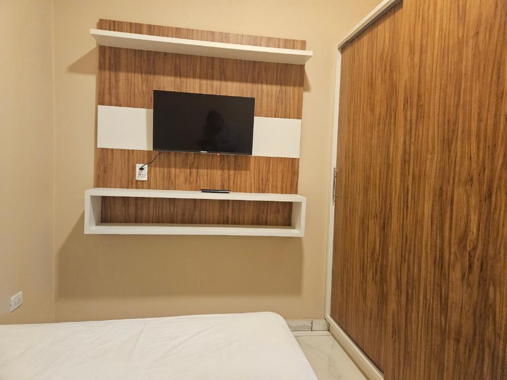 a bedroom with a bed and a tv on a wall at Urban Center Apartamentos in Salto del Guairá