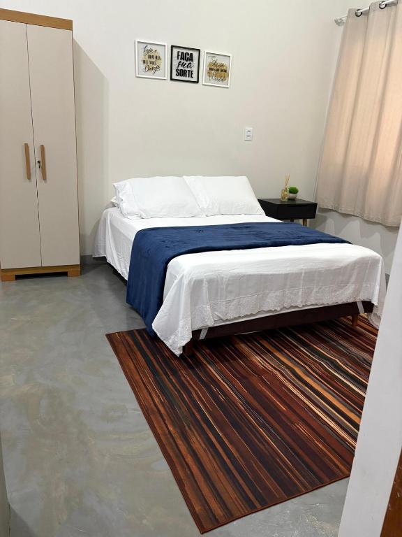 a bedroom with a large bed with a blue blanket at Studio 04 in Aracruz