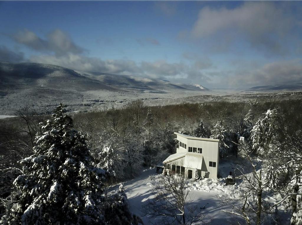 a white house in the snow with a tree at Stylish Catskills House Near Hunter Mountain & Trails in Elka Park