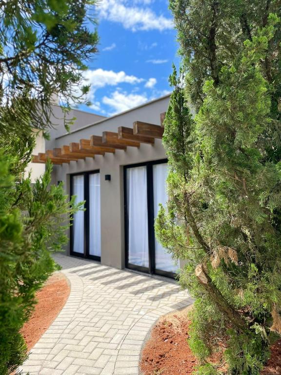 ein Haus mit Glasfenstern und einer Auffahrt in der Unterkunft Pousada Aurora - Com Lindo Jardim em Termas do Gravatal in Gravatal