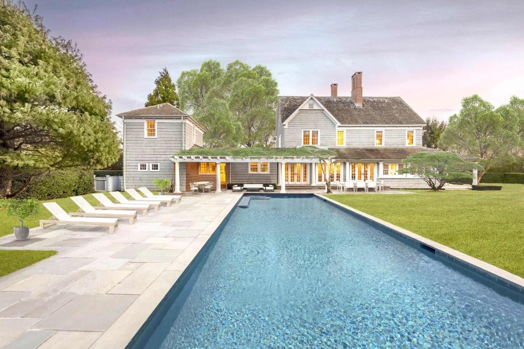 a house with a swimming pool in front of a house at Oceanstone by Rove Villa w Pool & Beach Access in Southampton