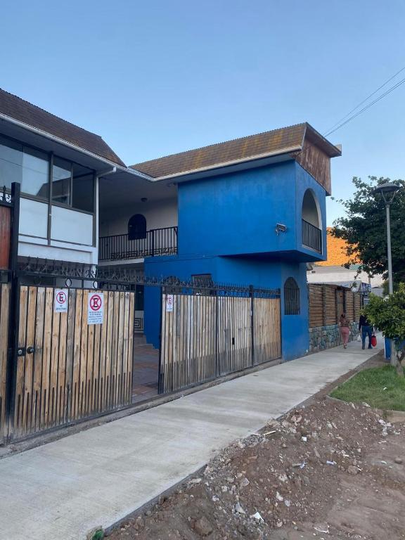 ein blaues Haus mit einem Zaun davor in der Unterkunft Hotel Del Valle in Illapel