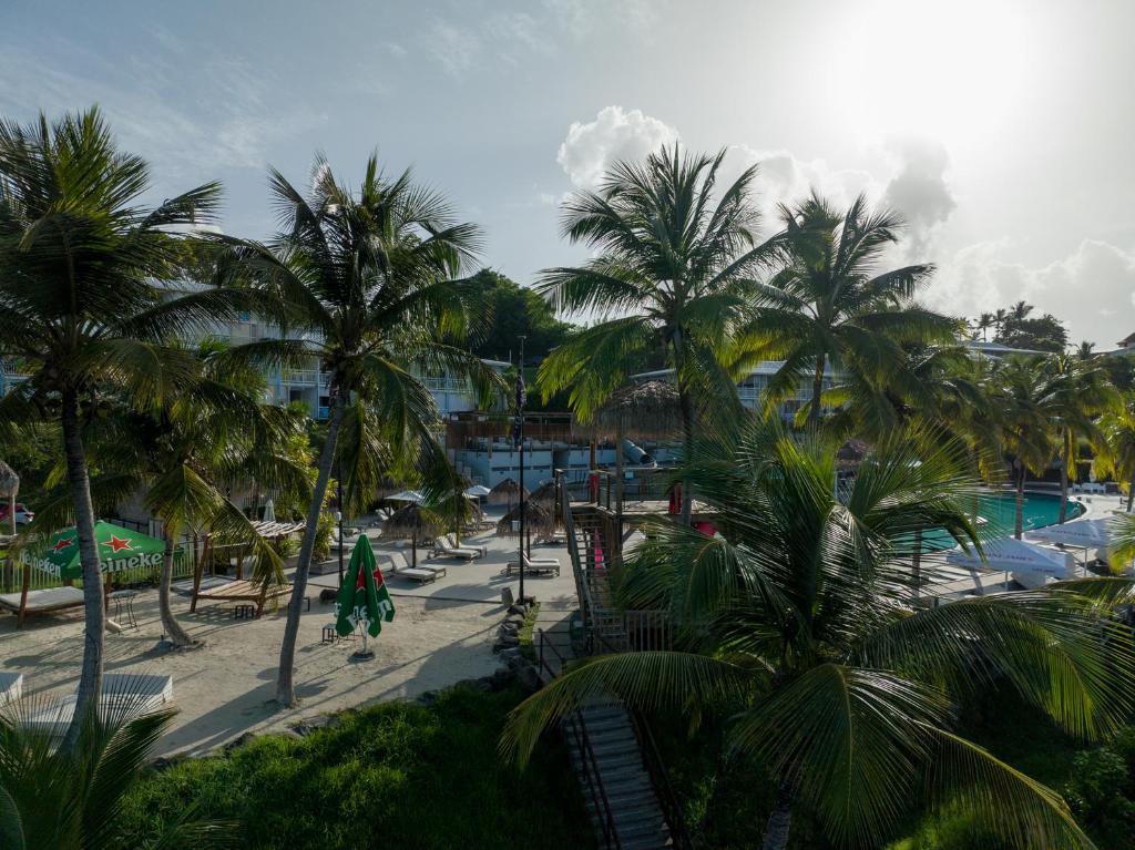 a view of a resort with palm trees and a pool at Gap Caraïbes in Le Diamant