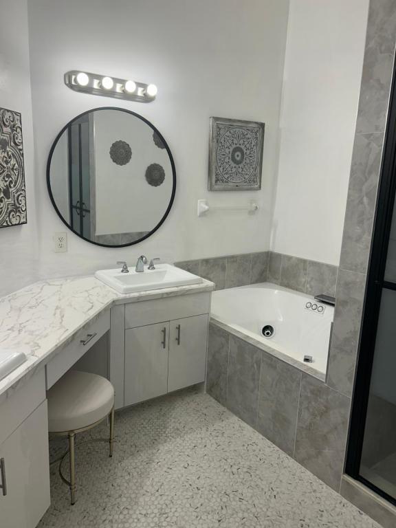 a bathroom with a sink and a tub and a mirror at Beautiful 2 Bedroom 2 Bathroom Condo in Naples