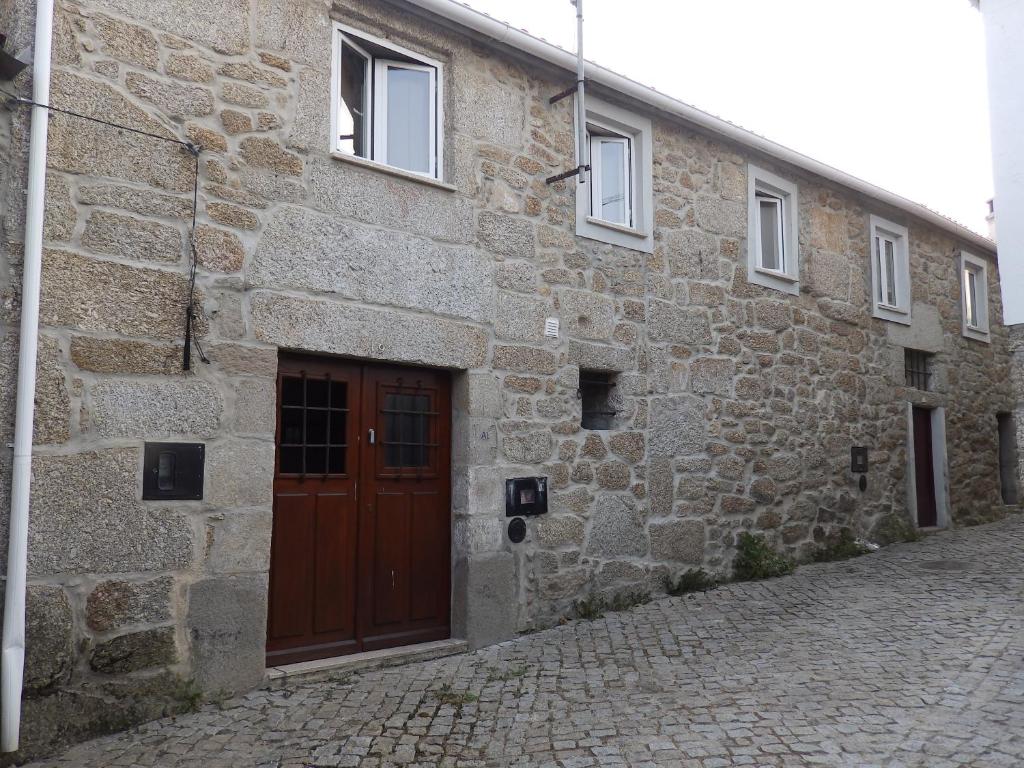 um edif�cio de pedra com uma porta castanha numa rua em Casas do Dur�o-Memories House em Lajeosa
