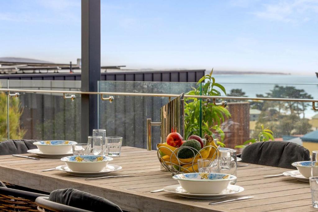 a wooden table with a bowl of fruit on it at Boston Beach House - BYO Linen in Lorne